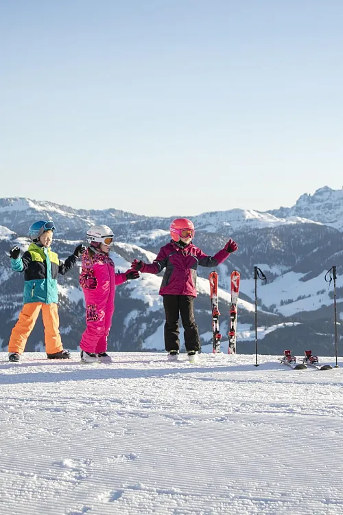 Kinder in Skiausrüstung im Skigebiet Kitzbühel in den Tiroler Alpen